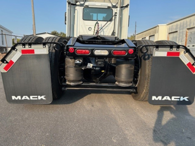 Mack AN64T tractor rear view showing dual turbofans and mud flaps with Mack logo, rear lighting, and hitch area.