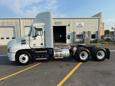 Tractor truck side view showing Mack AN64T cab and drivetrain with sleeper-high roof, dual rear axles, fuel tanks, and exhaust; no visible text on components.