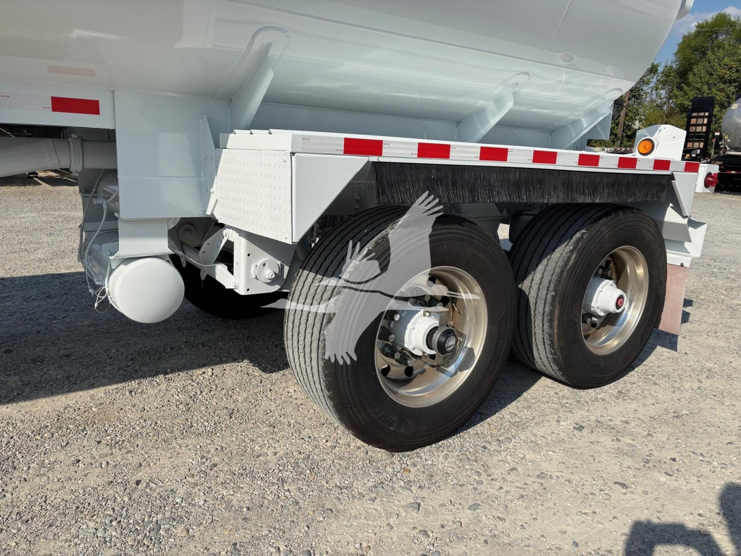 Trailer wheel assembly of a 2019 Heil 9200Gal tanker trailer showing dual rear axles and aluminum rims with white paint and reflective stripe.