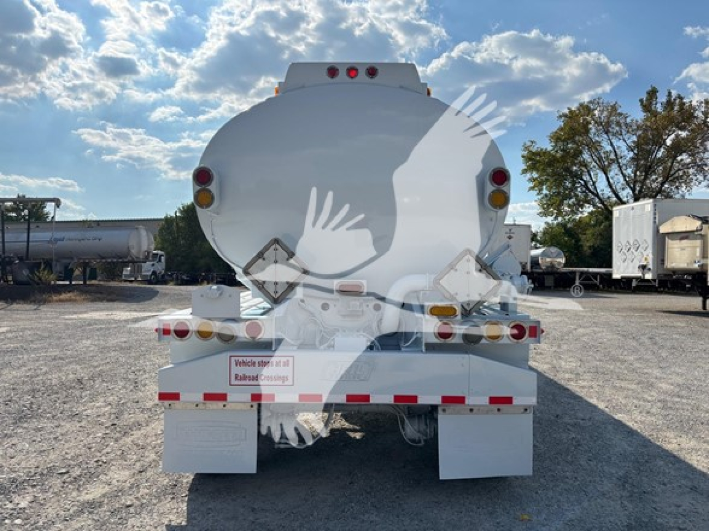 Heil Dot406 trailer rear view showing taillights, reflective tape, bumper, and warning placards.