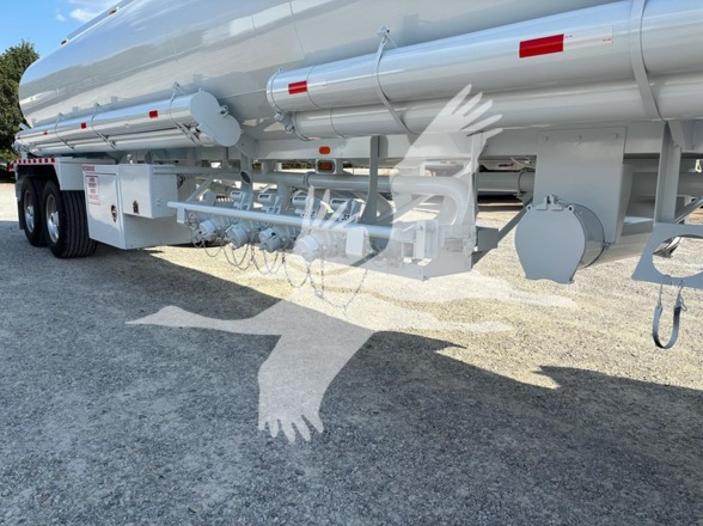 Trailer undercarriage showing hoses and fittings with reflective decals on a Heil Dot406 fuel trailer.