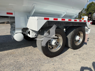 Trailer wheel assembly of a 2019 Heil 9200Gal tanker trailer showing dual rear axles and aluminum rims with white paint and reflective stripe.