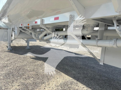 Trailer underside showing frame rails, suspension, and piping on Heil Dot406 trailer. Visible components include structural beams, cross members, support legs, hydraulic lines, and wheel/tire area partially visible.