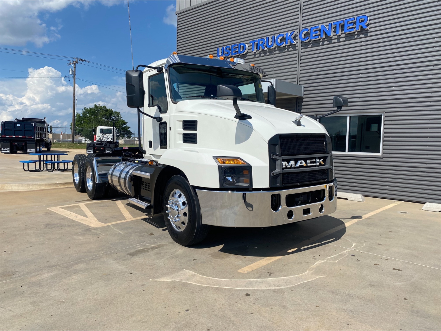 Mack AN64T conventional daycab truck in white, front three-quarter view, parked outside used truck center.