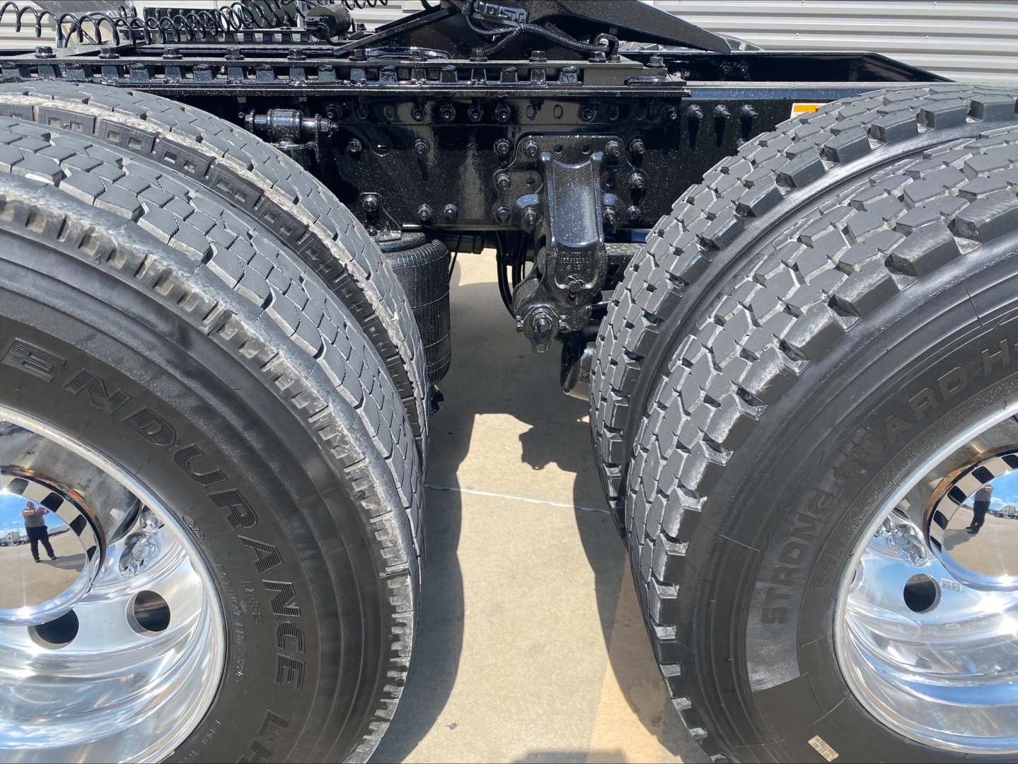 Mack AN64T truck rear dual rear tires showing chrome wheels and suspension; chassis frame under cab visible; treaded tires labeled 'ENDURANCE' or 'ENDURANCE' brand; no other text readable.