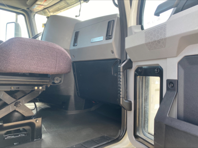 Cab interior of a 2021 Mack AN64T showing driver seat, dashboard panel, and open door