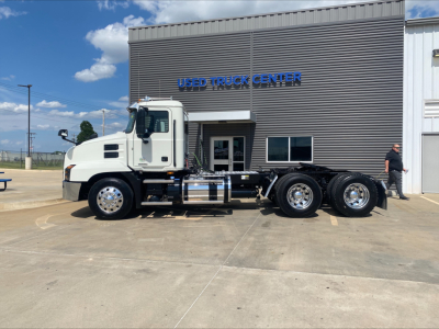 White 2021 Mack AN64T daycab truck with multiple axles parked in front of a Used Truck Center building; VIN 1M1AN2GY4MM022143 and stock number B3379P not visible in text on image.