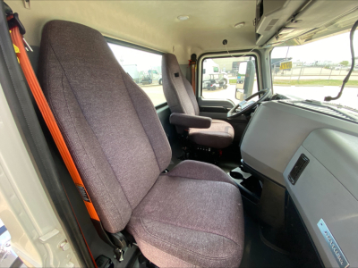 Mack AN64T truck cabin interior showing driver and passenger seats with grey fabric upholstery and dashboard view.