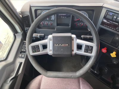 Mack AN64T dash and steering wheel interior showing Mack emblem on center of steering wheel with gauges in background