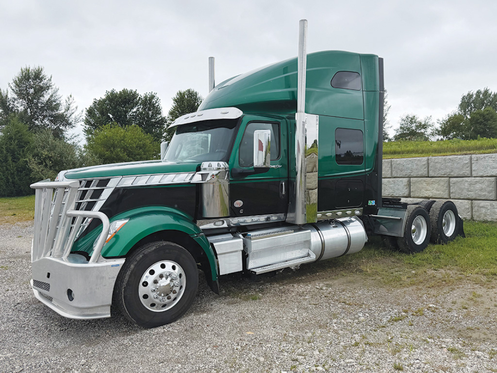 2022 International LoneStar sleeper tractor unit showing green cab and chrome exhaust stacks with dual rear axles.
