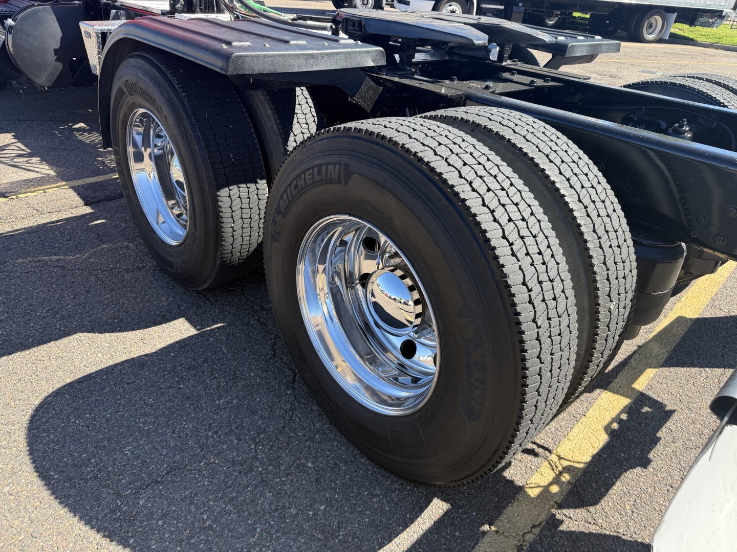 Kenworth T880 chassis showing dual rear axles with Michelin tires and chrome wheels.