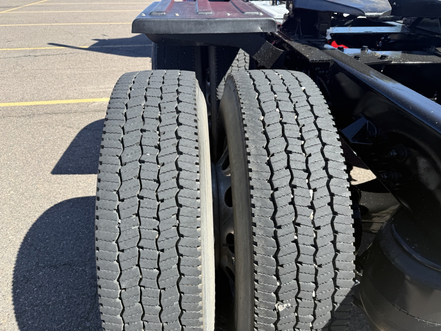Tandem rear tires of a 2020 Kenworth T880 truck chassis showing dual axles and tread pattern.