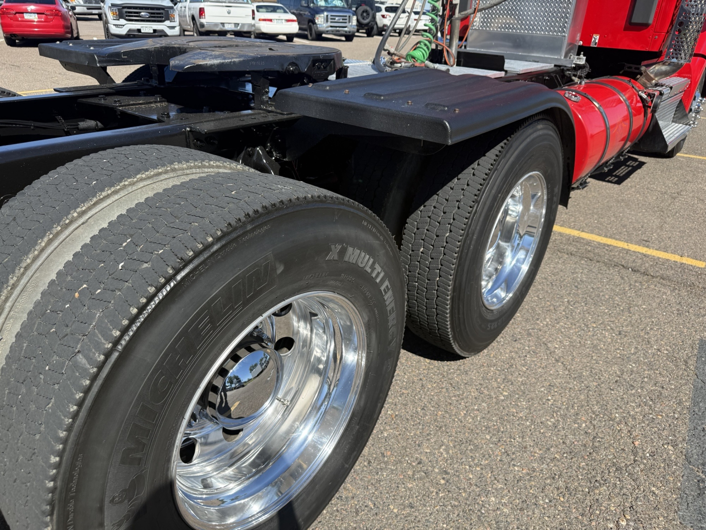 Kenworth T880 conventional daycab rear to middle view showing dual rear tires with polished rims and black fender flares.