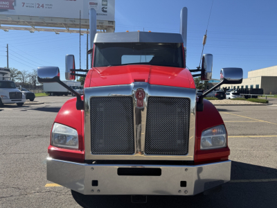 Kenworth T880 front view showing dual chrome grille, red cab, large chrome bumper, and rectangular headlights.