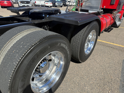 Kenworth T880 conventional daycab rear to middle view showing dual rear tires with polished rims and black fender flares.