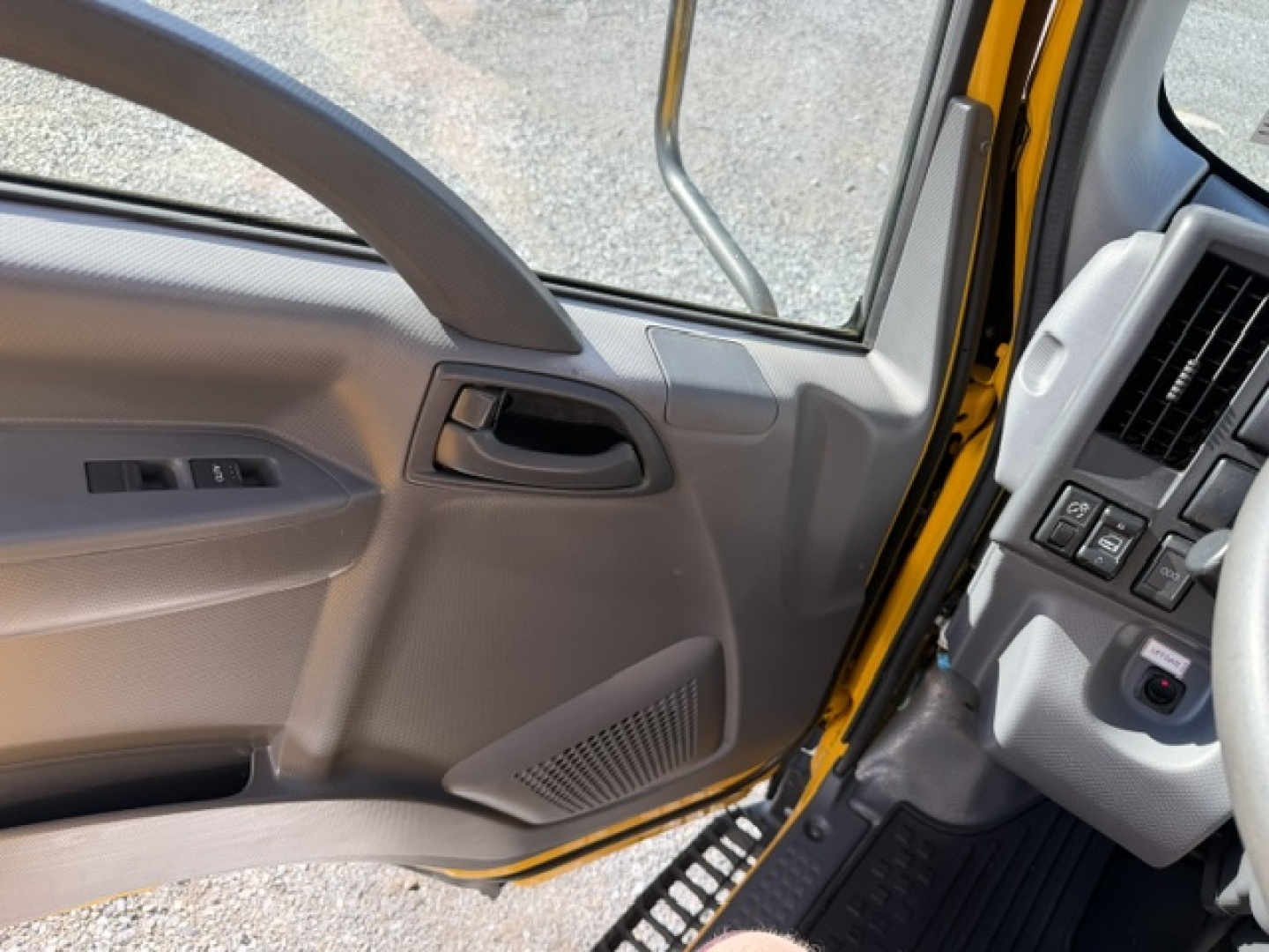 Isuzu NPR cab interior showing door panel with window controls and dashboard area