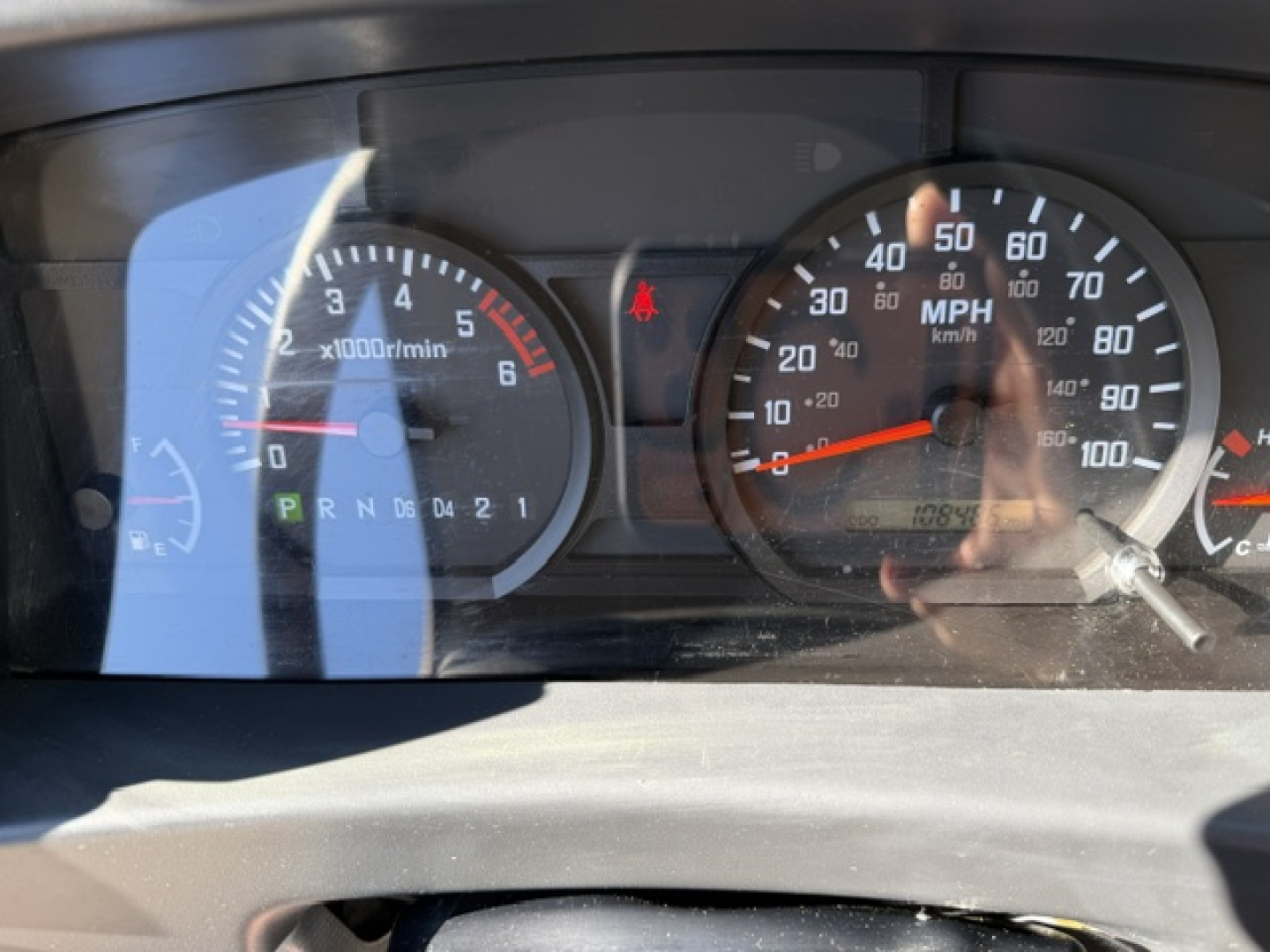 Dashboard of Isuzu NPR showing tachometer and speedometer with odometer and gear indicator.