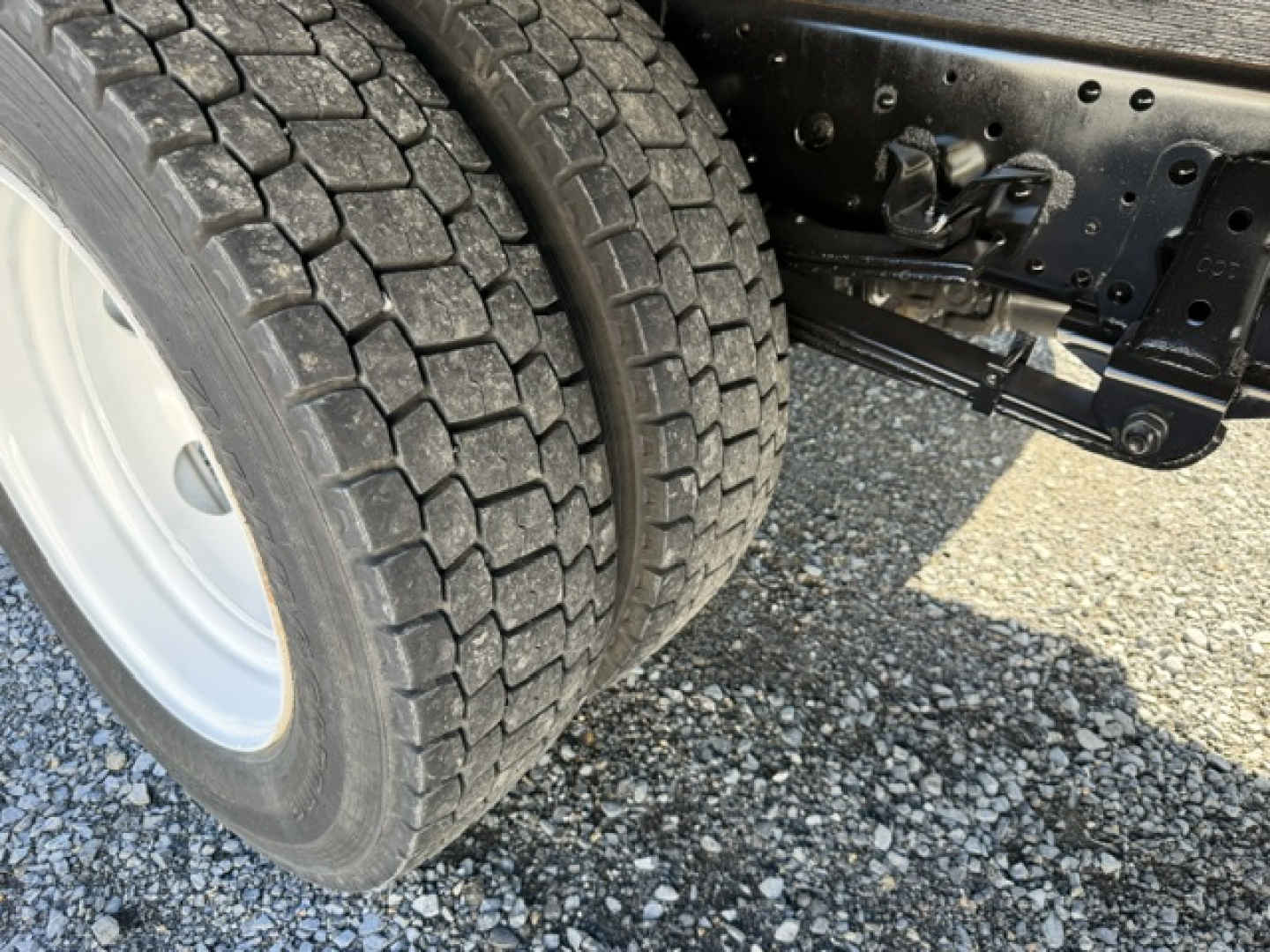 Isuzu NPR dual rear wheels and chassis view showing tire tread and wheel well. No readable labels or numbers visible besides general truck chassis.