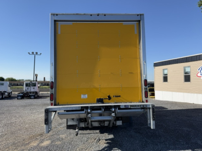 Isuzu NPR box truck rear view showing yellow cargo area and bumper with hitch, tail lights, and rear bumper structure.