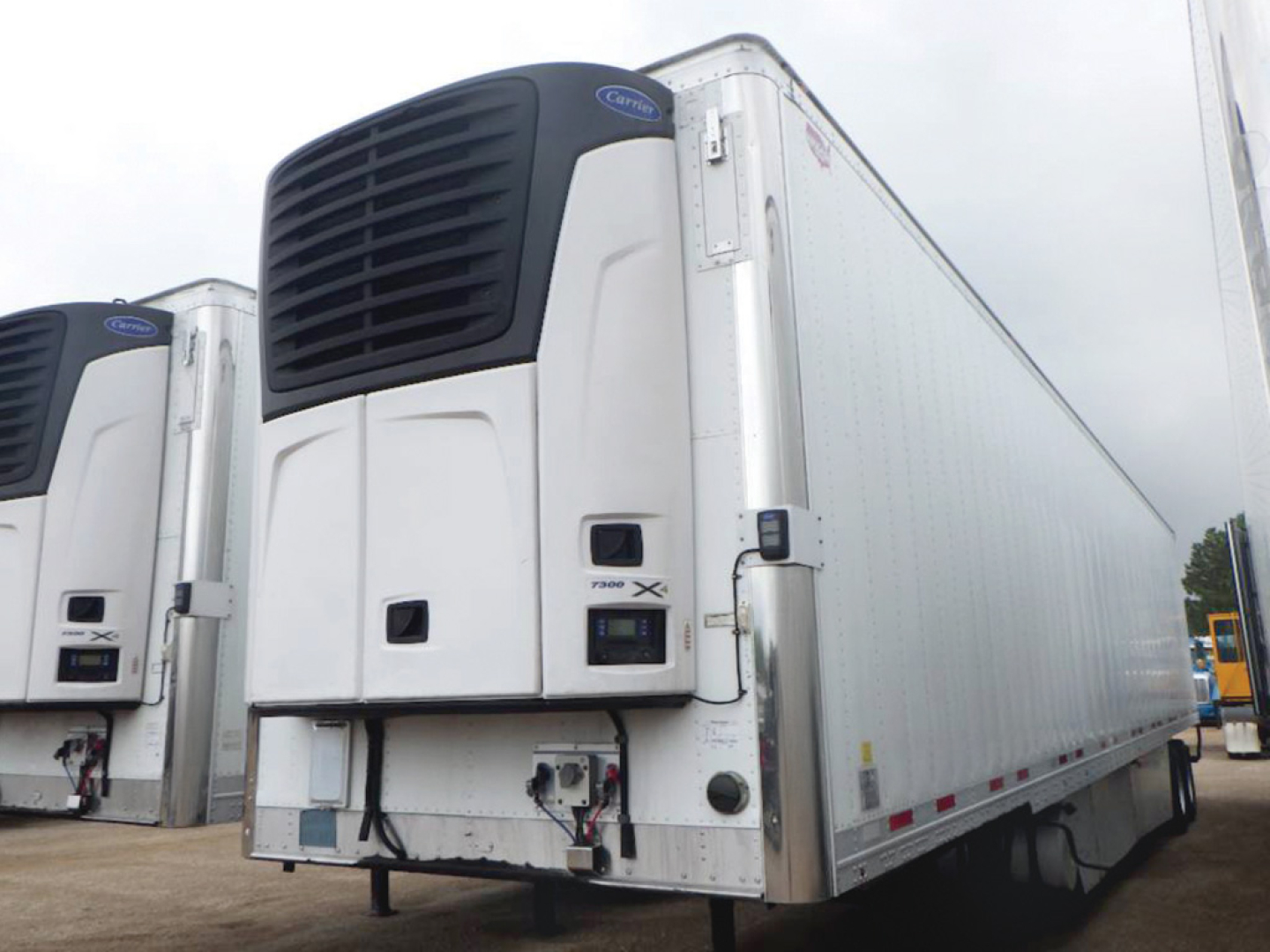 Trailer side and front of a 2018 Wabash ArcticLite refrigerated trailer showing Kenworth? No, unit is a reefer with cold plate front; white exterior with black refrigeration unit on front; visible side door and loading ramps; VIN label and