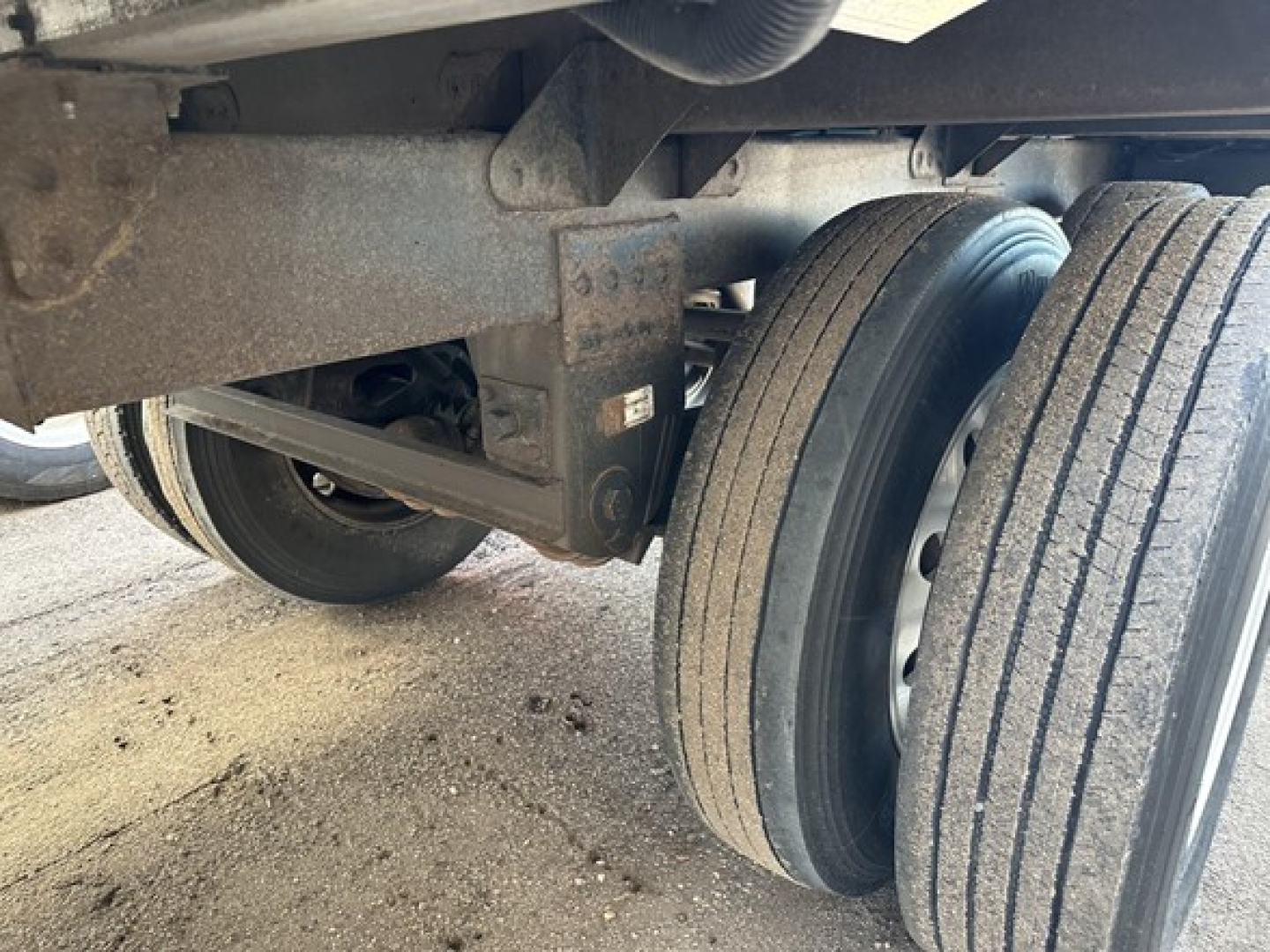 Trailer undercarriage with dual tires and suspension components visible; shows metal frame and wheel hubs.