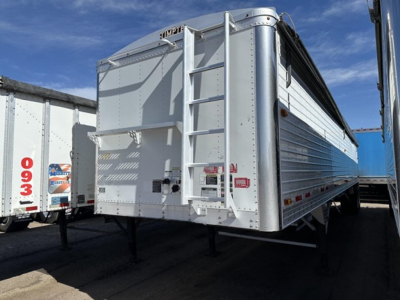 Trailer rear view of a silver Timpte Super Hopper aluminum trailer with a ladder and rear doors visible.