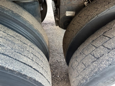 Timpte Super Hopper trailer wheels/axles close-up showing dual rear tires with dirt and wear, part of a used trailer.