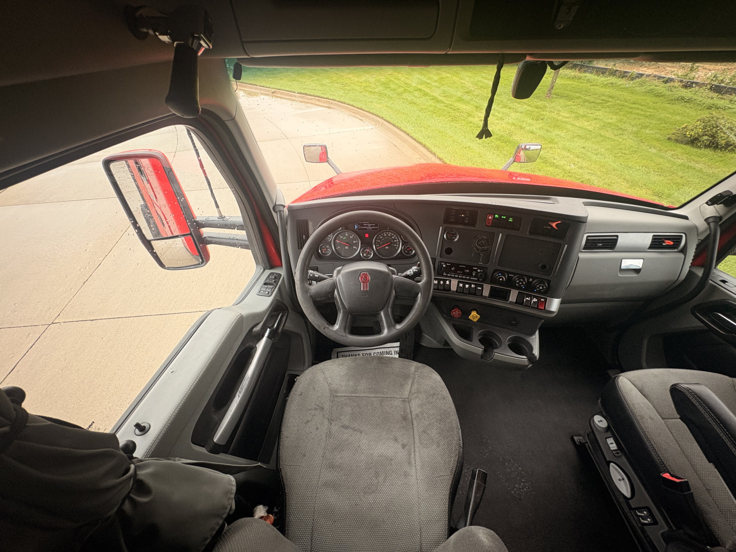 Kenworth T680 interior dashboard and steering wheel view from driver seat with US truck cab, instruments and controls visible.
