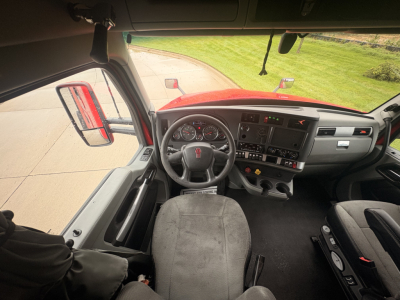 Kenworth T680 interior dashboard and steering wheel view from driver seat with US truck cab, instruments and controls visible.