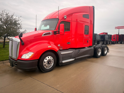 Red 2022 Kenworth T680 tractor truck side view showing aerodynamic cab and wheel hubs