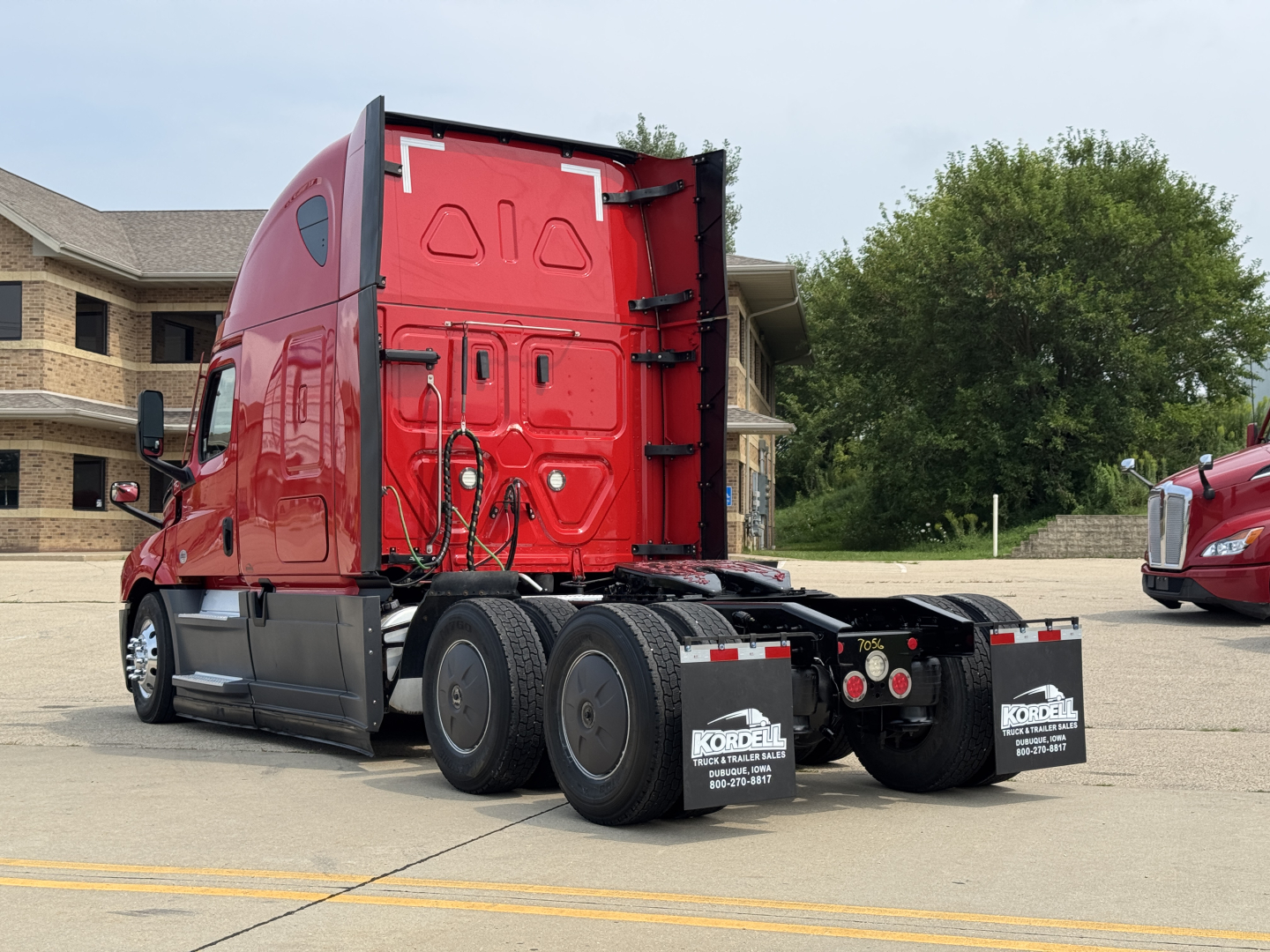 Freightliner Cascadia 126 rear view showing truck tractor with red cab and dual rear axles, stock number 2607056, VIN 1FUJHHDR9PLUE6911.