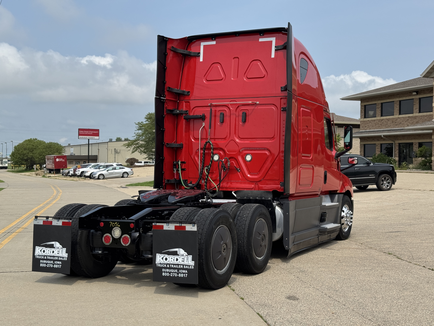 Freightliner Cascadia 126 tractor rear view showing dual rear axles and red sleeper cab