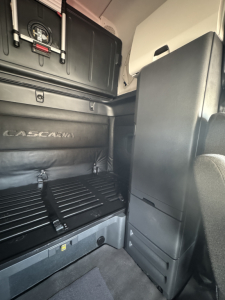 Freightliner Cascadia 126 sleeper cab interior showing storage cabinets and cargo area with brand name Cascadia on side panel.