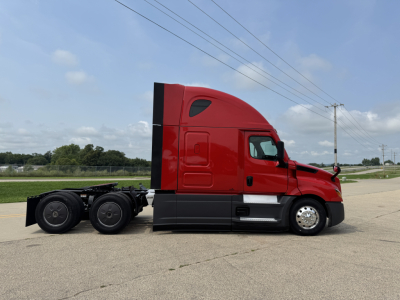 2023 Freightliner Cascadia 126 tractor side view showing red cab, black lower trim, chrome fuel tanks, rear dual axles, and window; no visible text readable on the image itself.