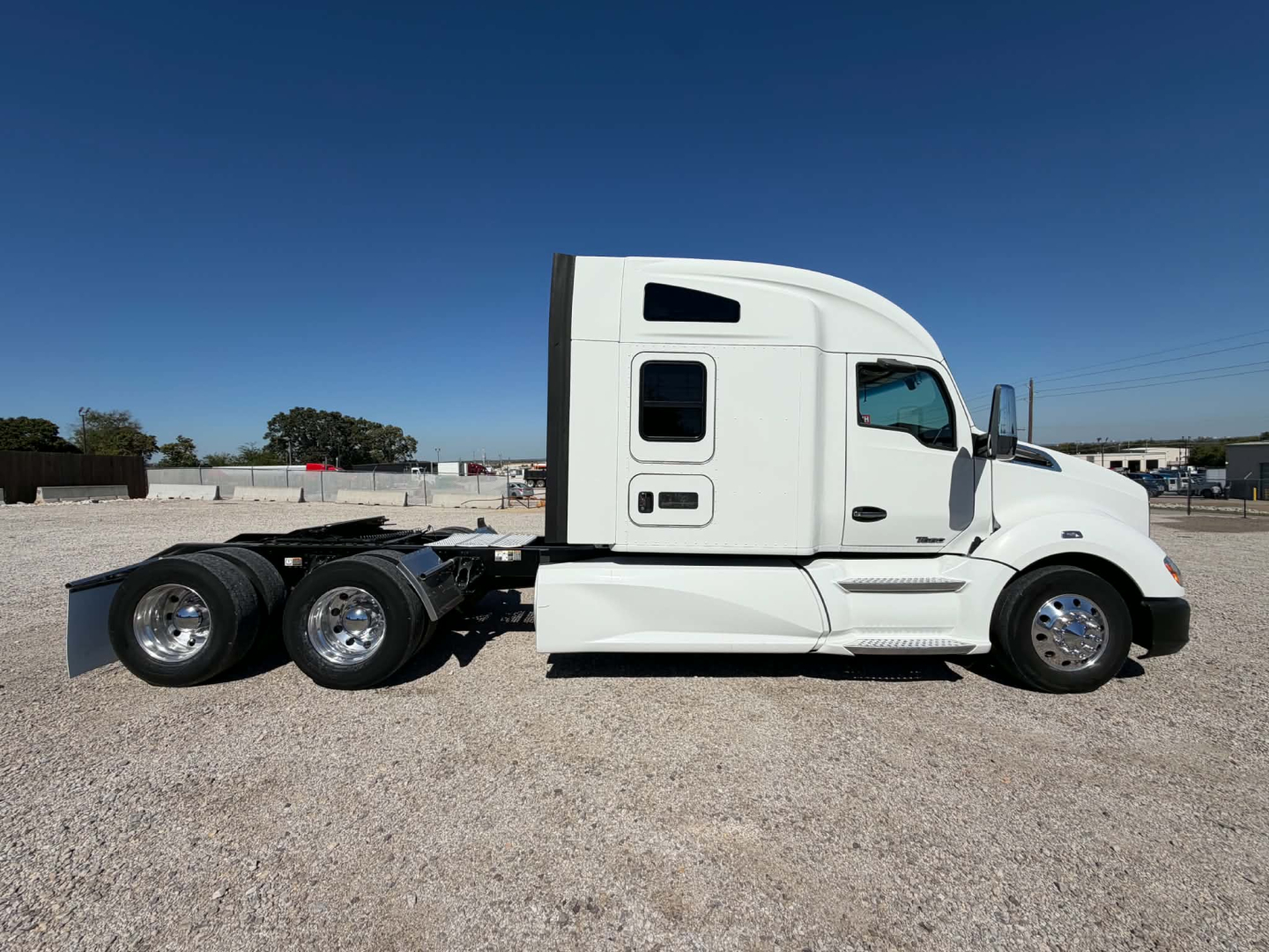 Kenworth T680 tractor in white side profile showing sleeper cab, rear wheels, and chassis. VIN 1XKYDP9X9KJ377525 visible in listing context.