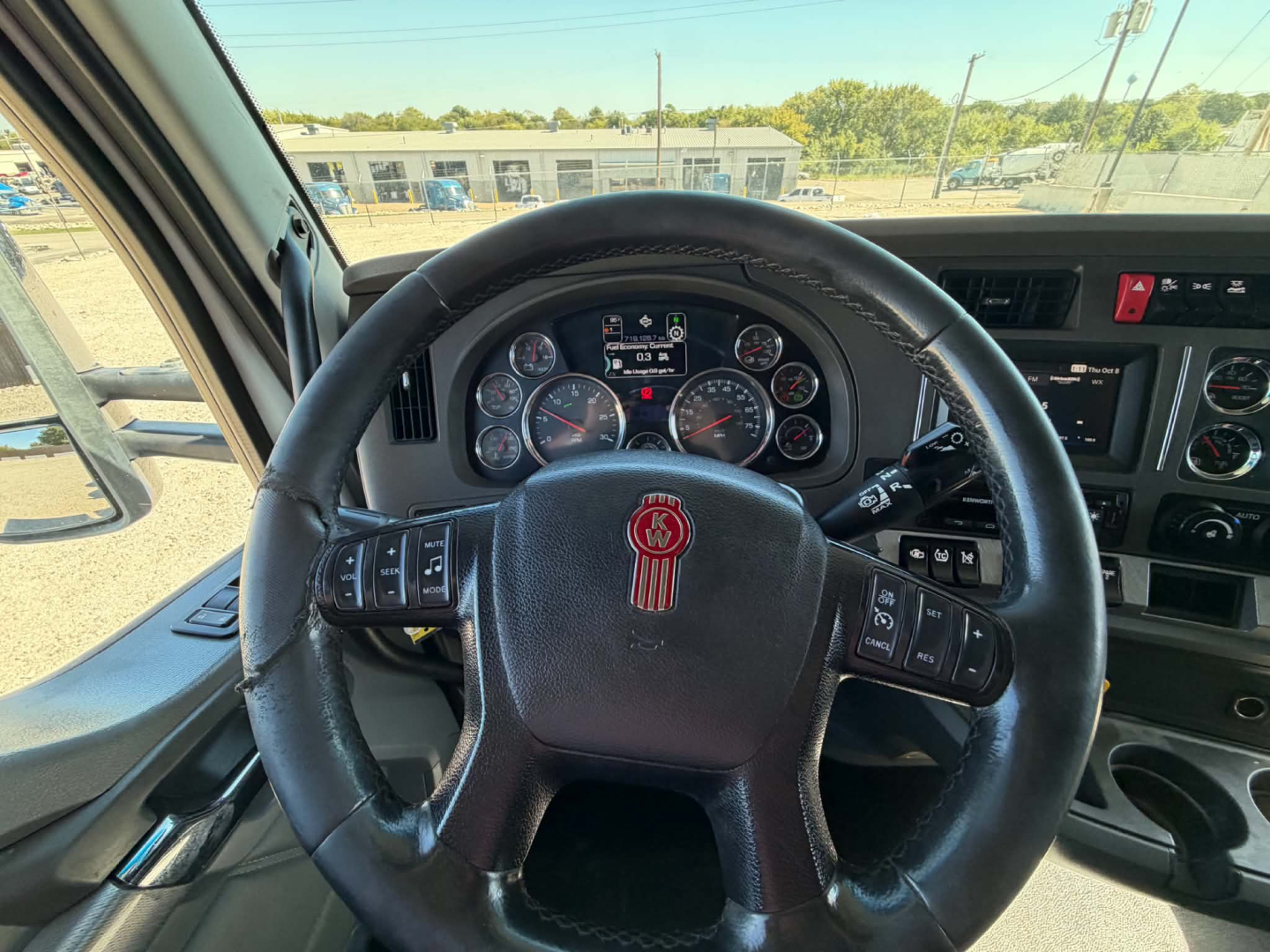 Kenworth T680 steering wheel and dashboard view with instrument cluster and control stalks visible.