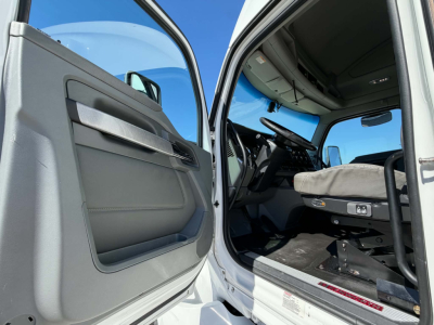 Kenworth T680 truck cabin interior with open door showing steering wheel and driver's seat, 2019 model, sleeper configuration.