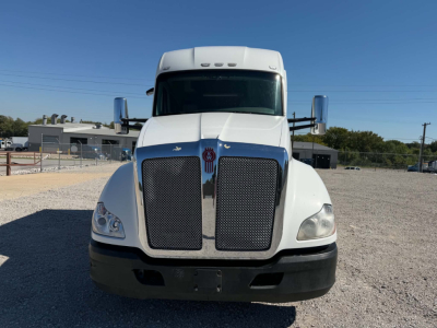 Kenworth T680 front view showing large black radiator grille, white cab, chrome mirrors, and license plate area.