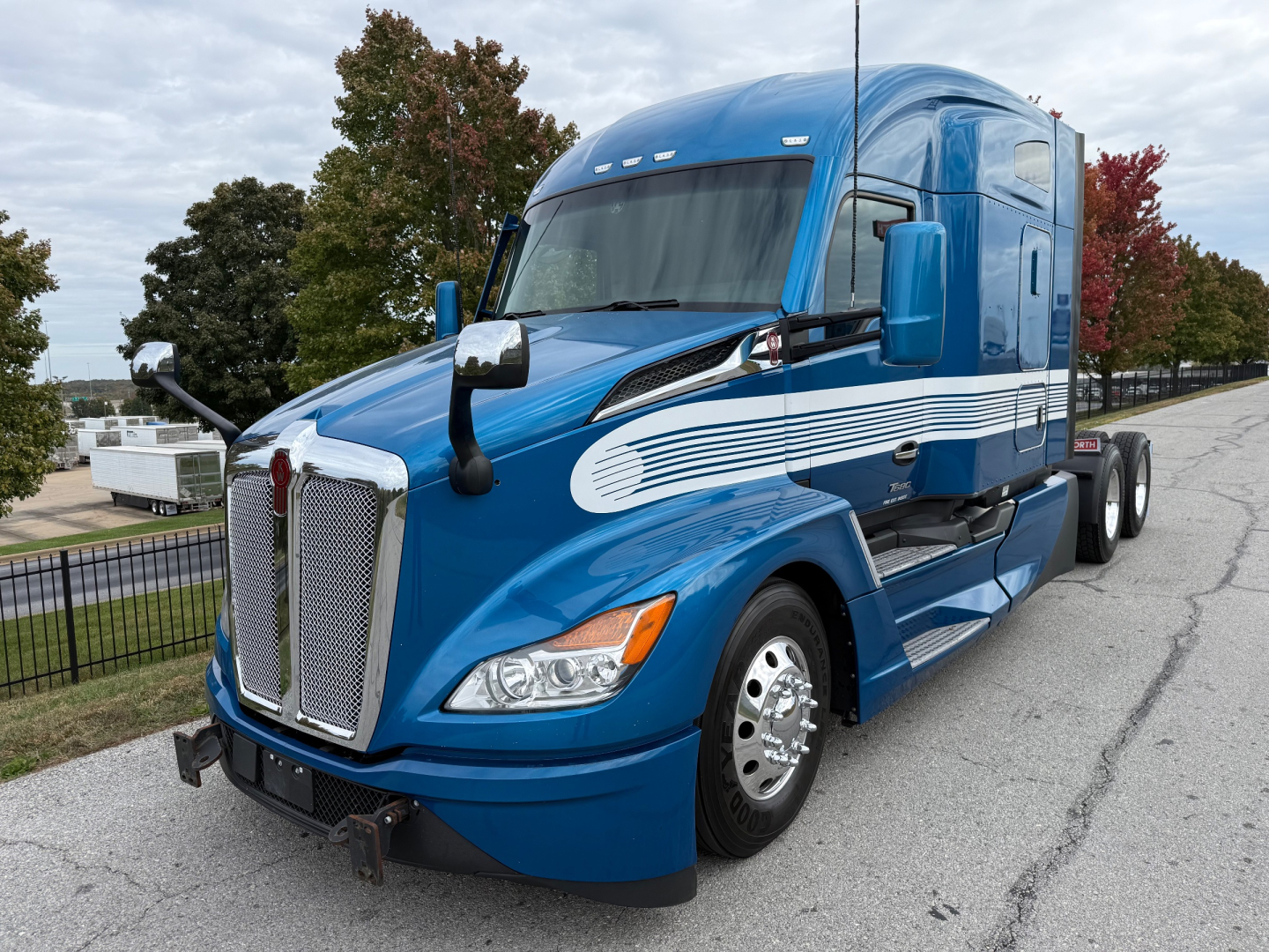 Kenworth T680 semi-truck in blue with sleeper cab, front grille, chrome mirrors, and dual rear wheels; VIN 1XKYD49X0PJ264469 not visible on image but listed in context.
