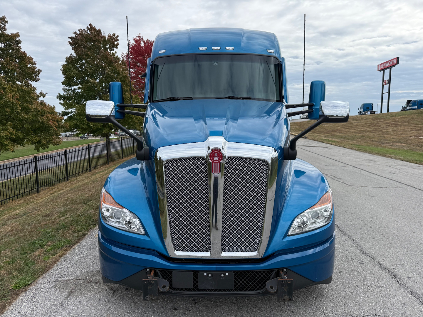 Kenworth T680 truck front view showing chrome grille and blue cab with large windshield.