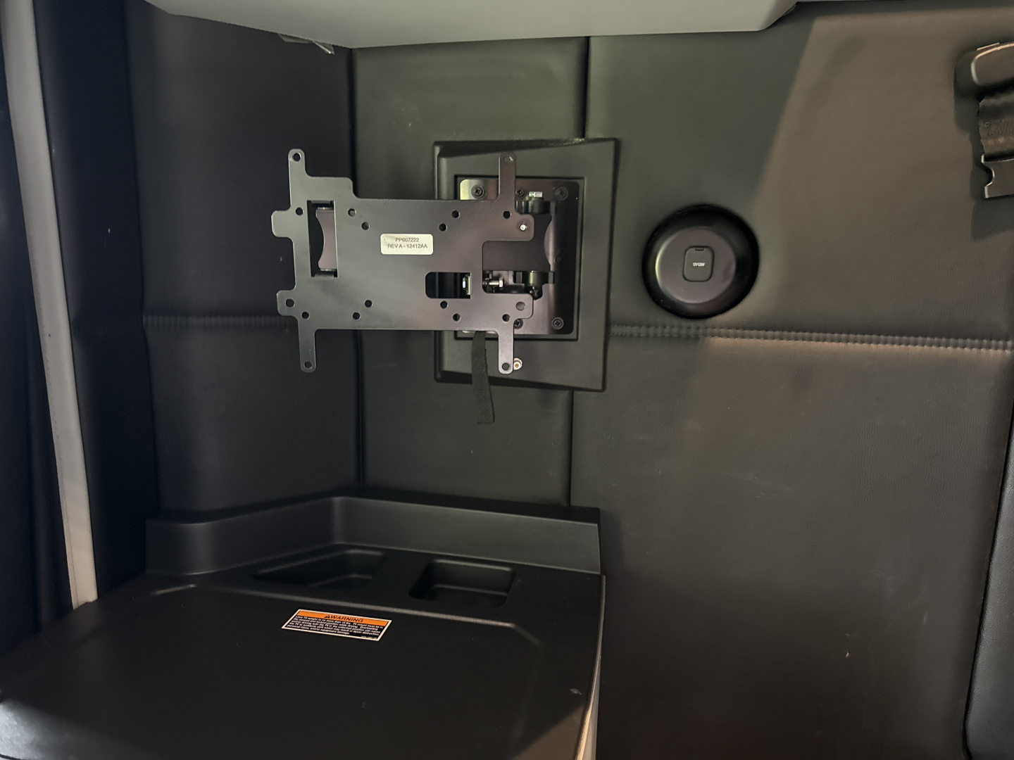 Kenworth T680 interior showing wall panel with a mounting bracket and a circular power port.