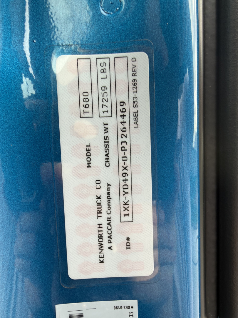 Kenworth T680 badge showing model T680, weight 172,559 LBS? unclear; label with VIN and stock number and codes.