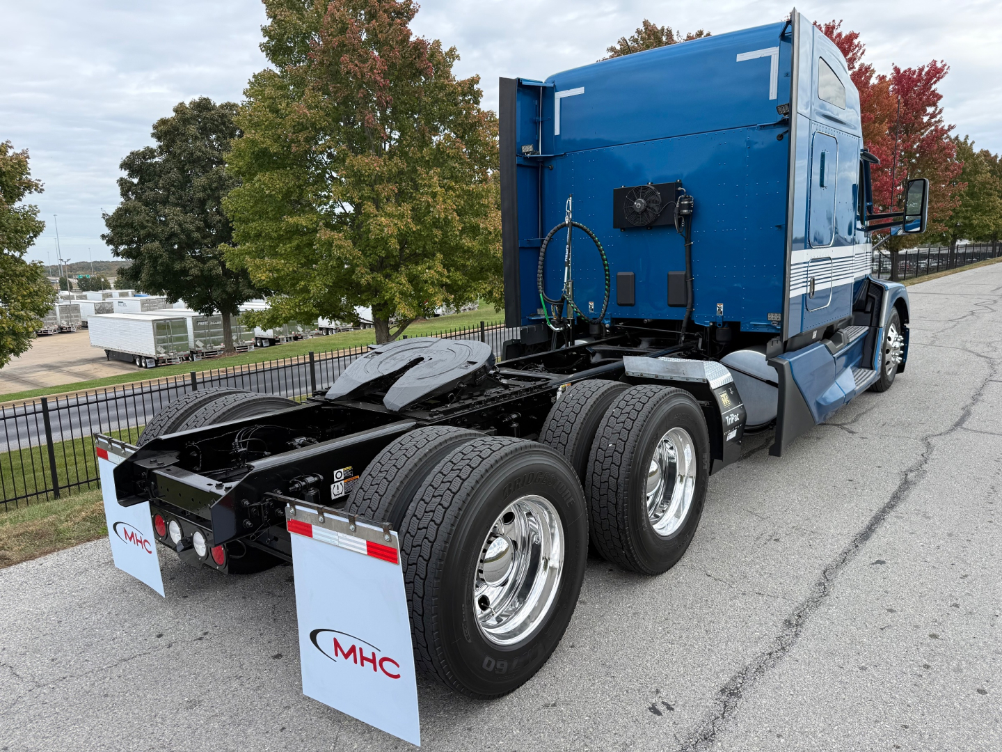 Truck chassis and cab of a blue Kenworth T680 with dual rear axles and fifth wheel.