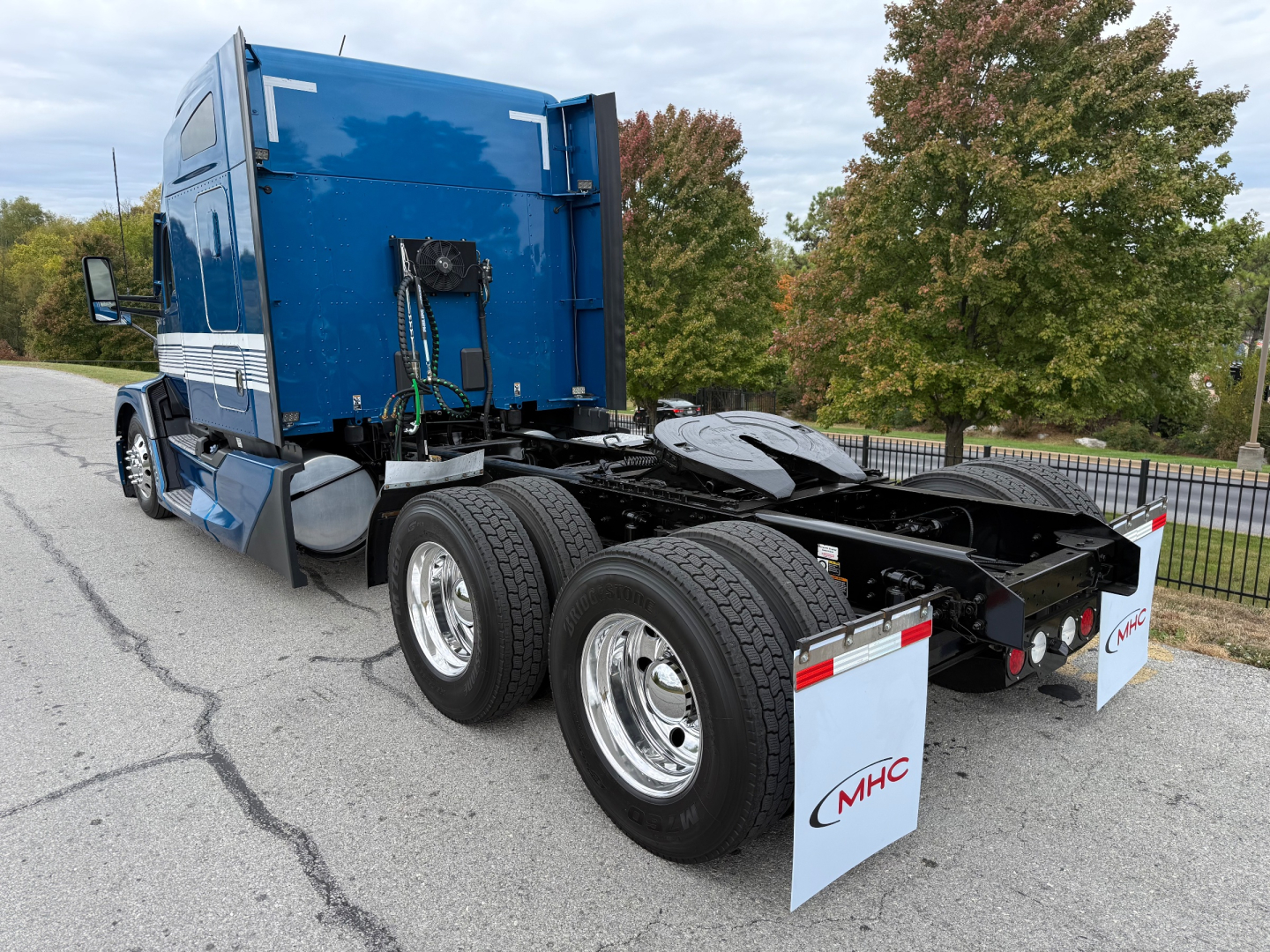 Kenworth T680 tractor side/rear view showing chassis, dual rear axles, and blue sleeper cab with mud flaps.