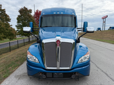 Kenworth T680 truck front view showing chrome grille and blue cab with large windshield.