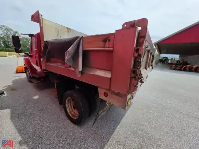 Dump truck bed with plow attachment, red International TerraStar dump truck, side view showing empty dump bed and rear tailgate with chains.