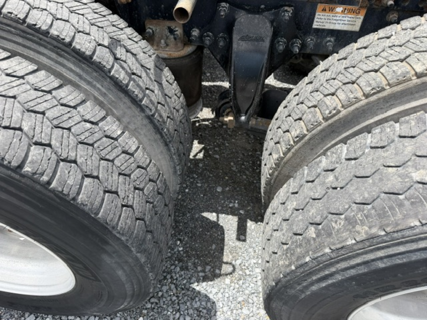 Freightliner Cascadia CA125DC engine bay view showing front dual wheels and suspension components.