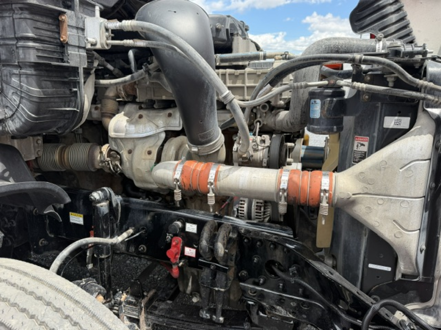 [Component] Engine bay view of a 2018 Freightliner Cascadia CA125DC showing engine, hoses, radiator, and wiring harnesses.