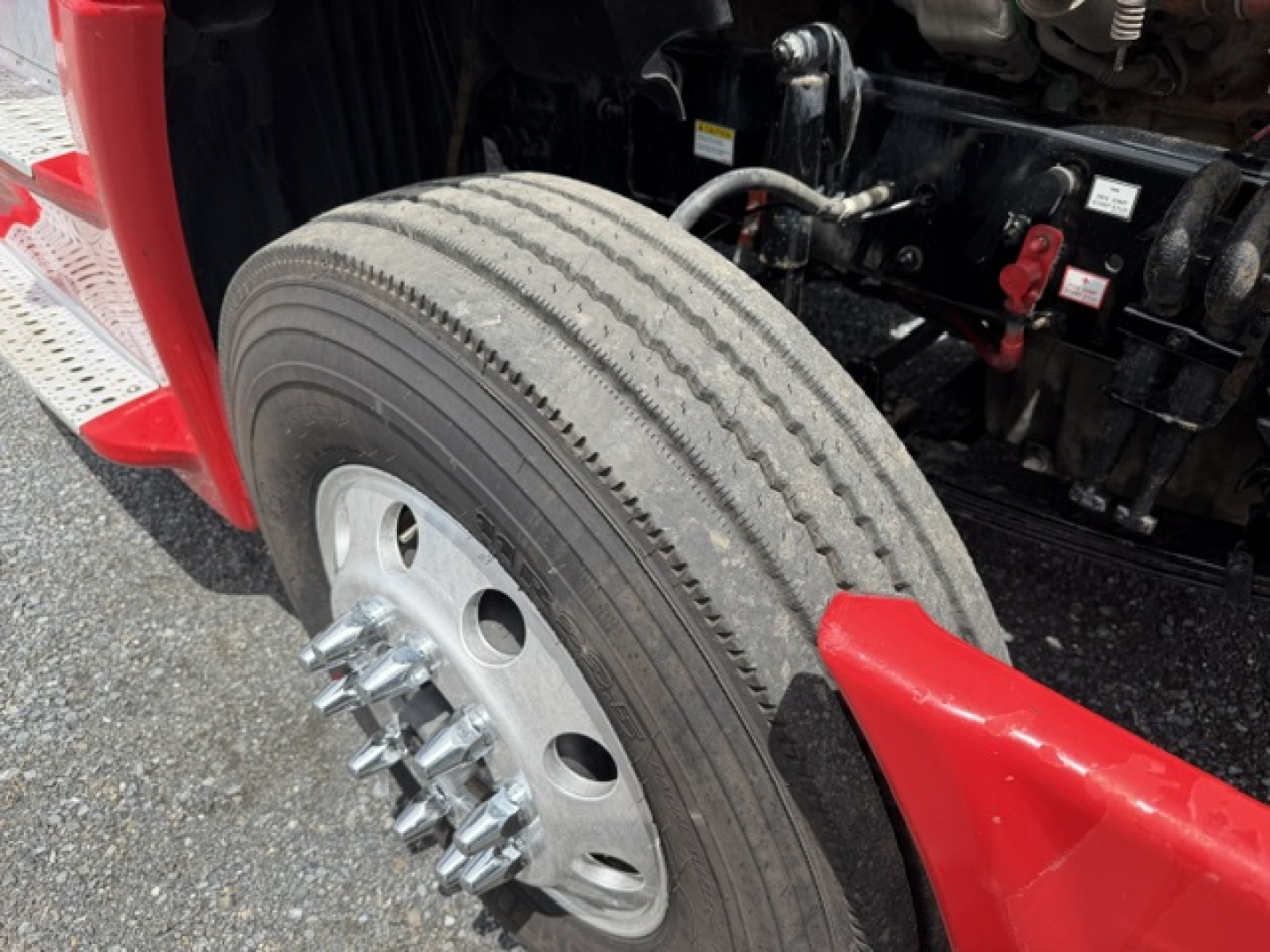 Truck wheel and front fender of a 2018 Freightliner Cascadia CA125DC with dual rear wheels and exposed suspension components.