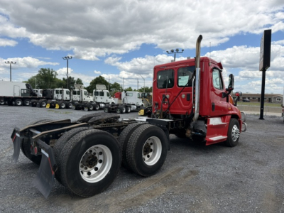 Freightliner Cascadia CA125DC truck cab and chassis showing rear dual axle and fuel tanks.